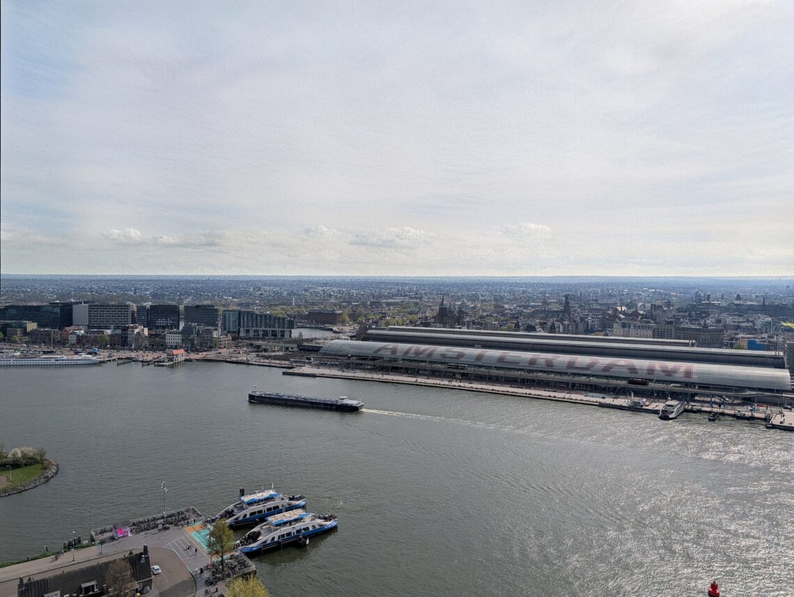 Birds eye view of the IJ river with the city of Amsterdam and Amsterdam Central Station in the background